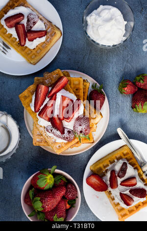 Traditionelle Belgien weichen Waffeln mit Erdbeeren und Puderzucker auf dunklem Hintergrund Stockfoto