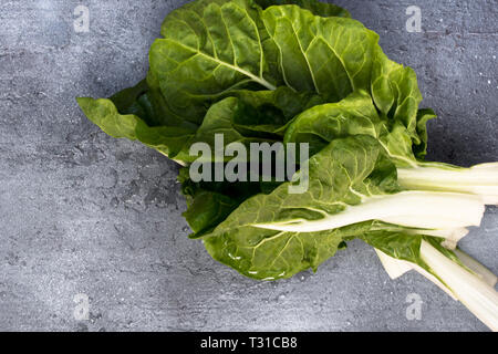 Stapel von frischem Mangold die Blätter auf dunklem Hintergrund. Stockfoto