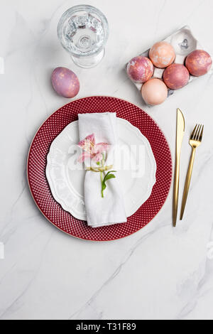 Servierteller für Ostern Frühstück mit Geschirr und Ostereier auf Marmor Hintergrund. Konzept der Kulinarische Ostern. Tabelle oben, flach, Konzept der Holida Stockfoto