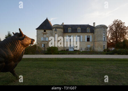 Die wunderschönen Chateau de Lescours mit seiner Unterschrift Stier Statue beleuchtet durch die untergehende Sonne. Stockfoto