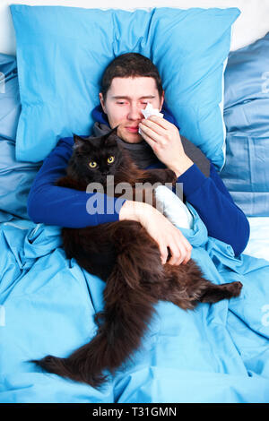 Foto von Kranken Schal mit Katze im Bett lag, Stockfoto