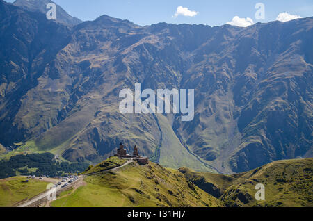 Sicht der Kirche der Heiligen Dreifaltigkeit in Kazbegi in der Nähe von Stepantsminda Kaukasus anzeigen Berge im Hintergrund. Stockfoto