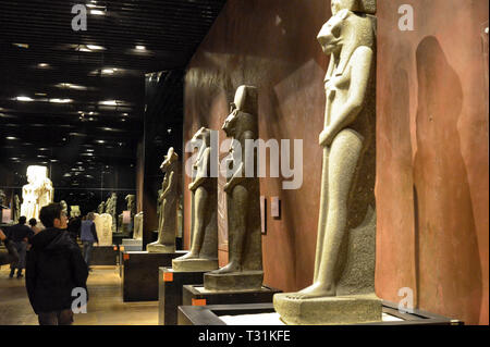 Turin, Piemont, Italien. März 2019. An das Ägyptische Museum, das große Zimmer zu Statuen gewidmet. Touristen in der Ausstellung. Stockfoto