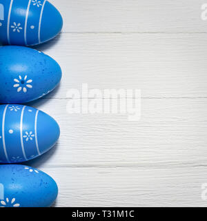 Ostern Hintergrund mit Eier in blauer Schrift auf weißem Holztisch. Ansicht von oben mit der Kopie. Platz Foto. Stockfoto