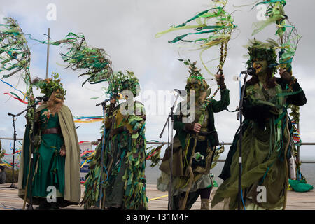 Eine weibliche Band in fabelhaften grünen Kostümen singen auf der Bühne auf die West Hill bei Jack im Grünen Festival, Hastings, East Sussex, Großbritannien Stockfoto