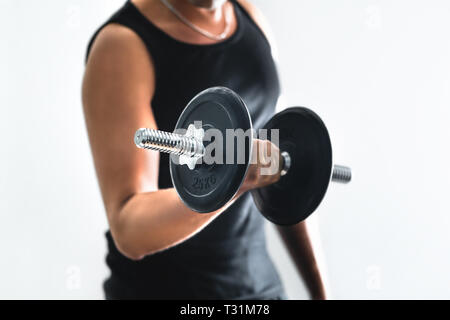 Mann trainiert Arme und macht bicep Locken mit Hanteln. Kerl arbeitet aus. Person Trainingsmuskeln. Workout-, Fitness- und Bodybuilding-Konzept. Stockfoto