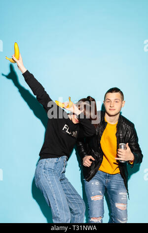 Coole Party. Close up fashion Portrait von zwei Jungen hipster Mädchen und Jungen Jeans tragen. Studio Schuß von zwei Modellen gemeinsam Spaß zu haben. Frau, die ein DAB-Bewegung mit den Armen. Menschliche Emotionen Konzept Stockfoto