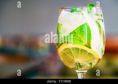 Glas mit köstlichen frischen hausgemachten Mojito auf unscharfen Hintergrund Stockfoto