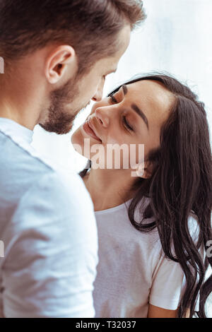 Schöner Mann und schöne Frau in t-shirt sich einander und küssen Stockfoto