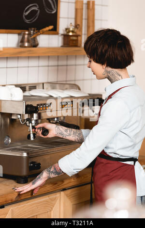 Selektiver Fokus der hübschen barista Kaffee auf Espresso Maschine Stockfoto