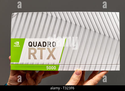 Paris Frankreich - Mar 28 2019: älterer Mann zeigen Kartons vor dem Auspacken des Nvidia Quadro RTX 5000 Workstation GPU mit neuen Tensor Kerne - grauer Hintergrund Stockfoto