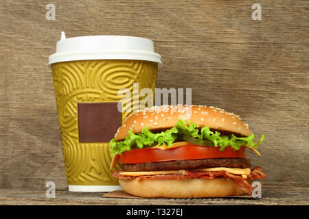 Große Hamburger und Papier Kaffeetasse auf alten hölzernen Hintergrund Stockfoto