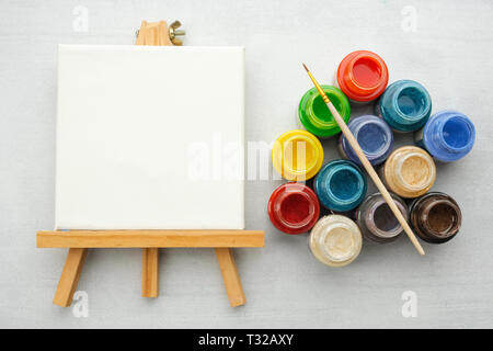 Bunte Farben mit Pinsel und Leinwand auf den Staffeleien, Ansicht von oben. Stockfoto