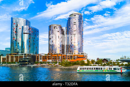 Ritz Carlton Hotel und die Türme an Elizabeth Quay mit einem TransPerth Fähre vorbei Stockfoto