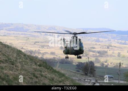 Eine rumänische IAR 330 "Puma" der Hubschrauber fliegt eine Praxis Landung an der Rolle 2 (Krankenhaus) Expeditionary medizinische Unterstützung von Fliegern aus dem 86Th Medical Group, Air Base Ramstein, Deutschland betrieben, während der Übung kräftiger Krieger 19, cincu Militärbasis, Rumänien, 5. April 2019. Kräftige Krieger 19 ist die NATO die größte militärische medizinische Bewegung, die mehr als 2.500 Teilnehmer aus 39 Ländern experimentelle Konzepte in der Lehre zu üben und Ihre medizinischen Vermögenswerte test zusammen in einem dynamischen, internationalen Umfeld (U.S. Air Force Foto von 1 Lt. Andrew Layton). Stockfoto