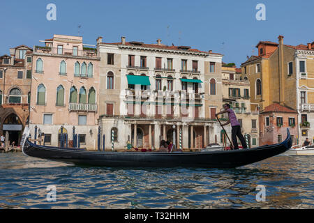 Venedig, Italien - Juli 2, 2018: Closeup Fotografie der Gondel mit Menschen und Gondoliere, im Hintergrund der historischen Gebäude des Grand Canal (Kann Stockfoto