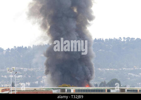 Rauch und Flammen schießen aus Oakland, CA-Lager Feuer April 1, 2019. Von Alameda Insel angesehen ca 1,6 Km entfernt Stockfoto