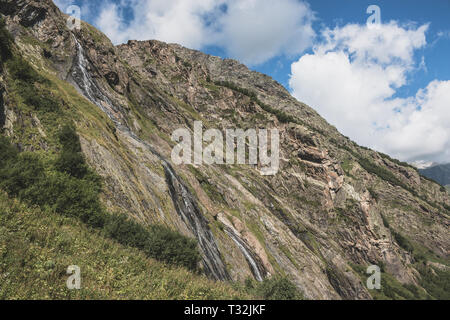 Panorama der Wasserfall Szene in Bergen, Nationalpark Dombay, Kaukasus, Russland. Sommer Landschaft, Sonnenschein Wetter, dramatische blauer Himmel und Su Stockfoto