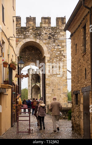 Die Menschen verlassen die mittelalterlichen Gassen von Besalu über die befestigte Brücke Stockfoto