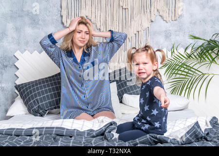Tochter weinend saß in der Nähe der Mutter auf dem Bett im Schlafzimmer Stockfoto