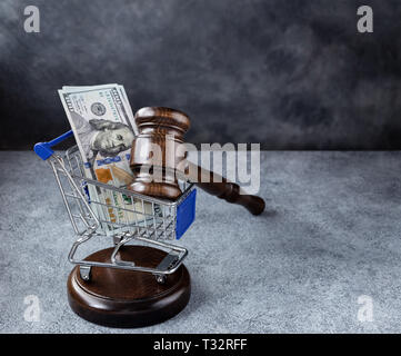 Hammer und Dollar in den Einkaufswagen Warenkorb auf grauem Hintergrund mit kopieren. Korrupten Gerichtsverfahren Konzept Stockfoto
