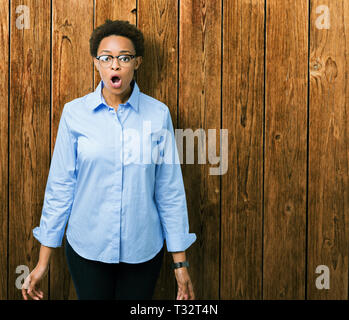 Junge schöne afrikanische amerikanische Geschäftsfrau über isolierte Hintergrund Angst und mit Erstaunen Ausdruck, Angst und aufgeregt Gesicht schockiert. Stockfoto