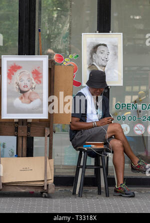 Ein Straßenkünstler in Phuket, Thailand malt Bilder und Porträts von Urlaubern und Reisenden auf einer Straße in patong. Stockfoto