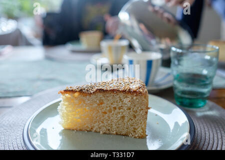 Ein Stück hausgemachten vasilopita, einem traditionellen griechischen Neues Jahr Kuchen mit Sesam gekrönt. Die vasilopita ist um Mitternacht mit einem L-Schnitt Stockfoto