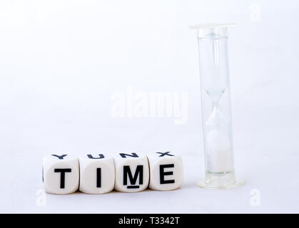 Der Begriff der Zeit in schwarzen Text zusammen mit einer Sanduhr auf weißem Hintergrund Bild mit Kopie Raum isoliert Stockfoto