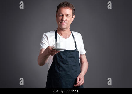 Ein Mann mittleren Alters dienen eine Tasse Kaffee Stockfoto