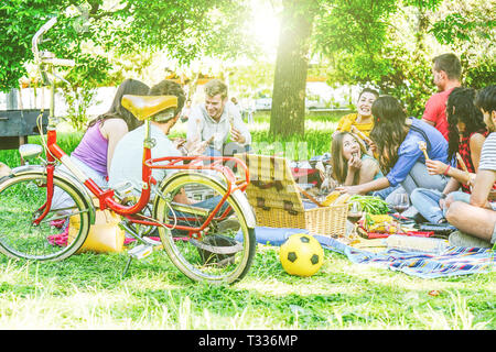 Gruppe von einer Menge Leute in ein leckeres Picknick essen und trinken Rotwein in einem Park Outdoor - glückliche Freunde feiern einen sonnigen Tag, Lebensmittel Stockfoto