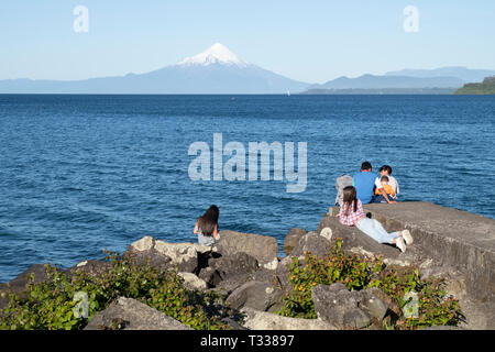 Jugendliche an der Uferpromenade von Puerto varras mit Osmo Vulkan im Hintergrund Stockfoto