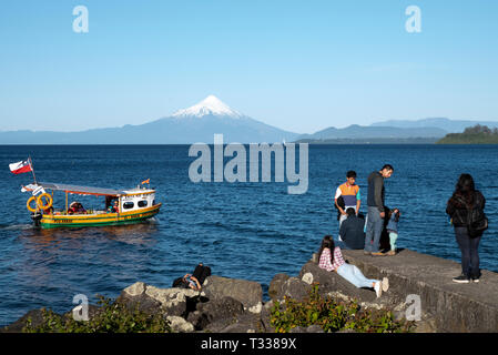Blick von der Uferpromenade am Puerto varras in Richtung osmo Vulkan mit Jugendlichen Stockfoto
