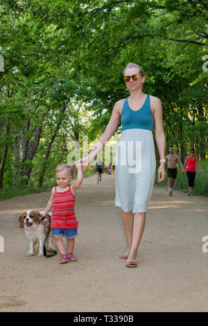 Mutter, Mädchen Kleinkinder- und Cavalier King Charles Spaniel, am Kellermeister Trail im Zilker Park in Austin, Texas, USA Stockfoto