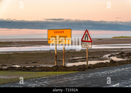 Zeichen: Einzelne Datei Verkehr, Gefahr, fahren Sie nicht fort, wenn Wasser Causeway erreicht, an der Straße zwischen Beal und Heilige Insel in Northumberland, England gesehen Stockfoto