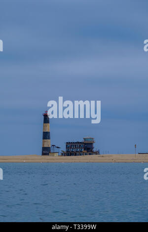 Blaue und weiße Streifen von Pelican Point Lighthouse weiter auf Streifen Sand Lodge im Atlantischen Ozean mit BIRDLIFE am Ufer gelegen Stockfoto