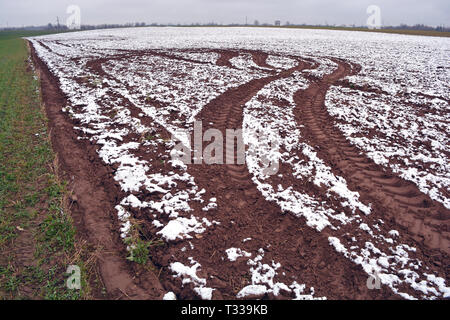 Im Herbst gepflügt Bauernhof Feld mit dem ersten Schnee und Traktor Titel Stockfoto