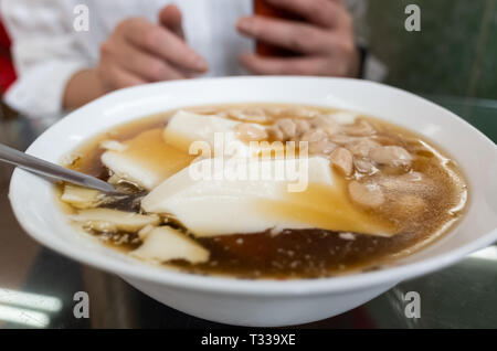 Frau essen berühmten Taiwan Snacks von Tofu Pudding Stockfoto