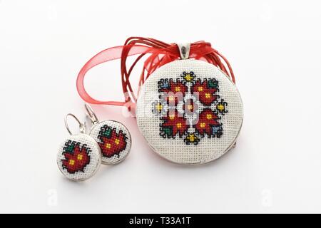 Handmade Cross Stitch Schmuck Set rote Blumen bestickt auf der weißen Leinwand Stockfoto