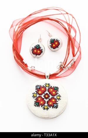 Handmade Cross Stitch Schmuck Set rote Blumen bestickt auf der weißen Leinwand Stockfoto