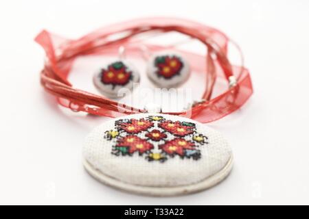 Handmade Cross Stitch Schmuck Set rote Blumen bestickt auf der weißen Leinwand Stockfoto