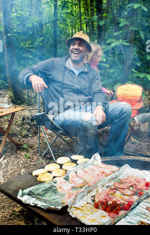 Kochen ein großes Frühstück über einem offenen Feuer in der Wildnis Wald Campingplatz in Sussex, UK Stockfoto