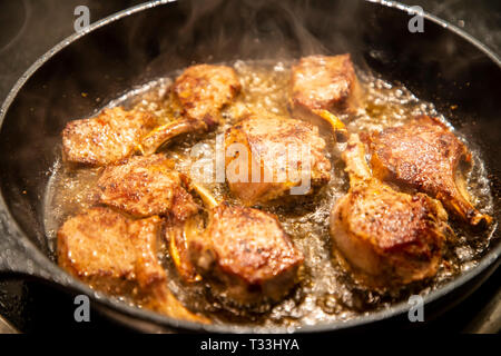 Kochen, Fleisch, Lamm Koteletts werden in einer Pfanne gebraten, Stockfoto