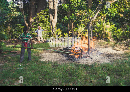 Prozess der Verbrennung in der Andamanen und Nikobaren. Hindu Traditionen. Die Inselbewohner des Verstorbenen auf dem Lagerfeuer am Ufer des t verbrannt Stockfoto