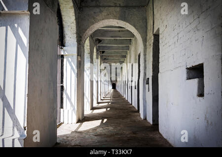 Langen Korridor in Cellular Jail, Port Blair, Andaman Inseln, Indien. Einzelhaft Zellen entlang der weißen Wand eines alten Gefängnis Stockfoto