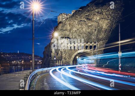 Nacht der Verkehr in der Stadt. Leichte Spuren von Straßenbahn und Autos auf der Straße auf Vysehrad Tunnel. Prag, Tschechische Republik