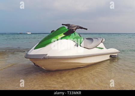 Weiß-grün Jet Ski am Ufer inmitten einer wunderschönen Landschaft geparkt. Wasser Unterhaltung am Meer. Sommer Tourist Ferien am Meer. Stockfoto