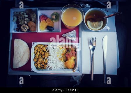 Satz von Inflight Mahlzeit in einem Feld, auf dem Klapptisch in der Economy Class. Die Fütterung der Passagiere der Asiatischen Essen im Flugzeug in Kasachstan. Die Reise tou Stockfoto