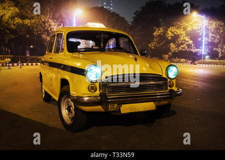 Ein gelbes Taxi Modell 50s-60s. Alten retro Auto in Form von einem Taxi in die Stadt in der Nacht, in der Straße von Kalkutta. Indien Stockfoto