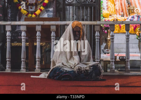 Rishikesh. Indien. 10. Januar 2018. Indischen Sadhu, Heiliger Mann vor einem Hindu Tempel sitzen. Stockfoto